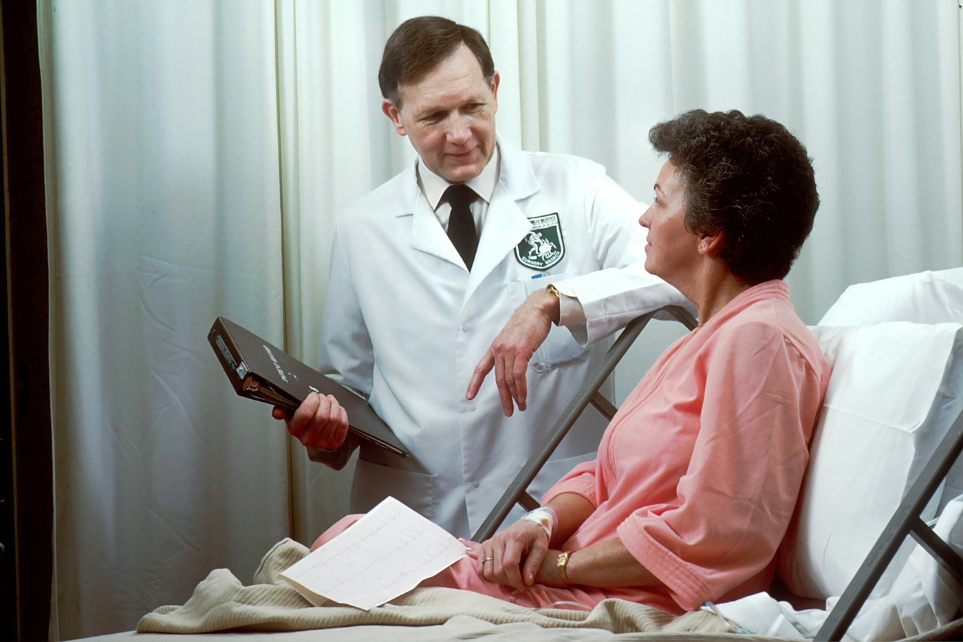 A doctor with a tablet talking with a patient