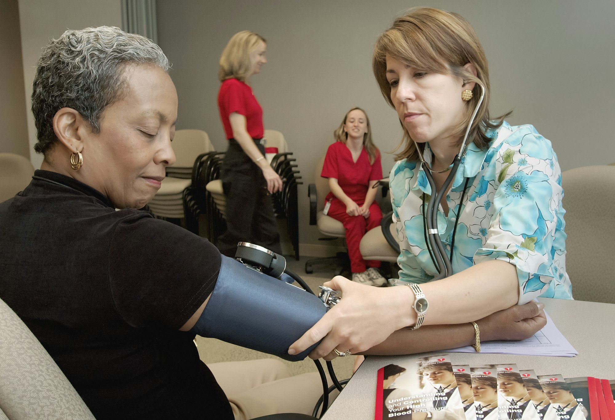 A clinician checking a patient's blood pressure during a health check