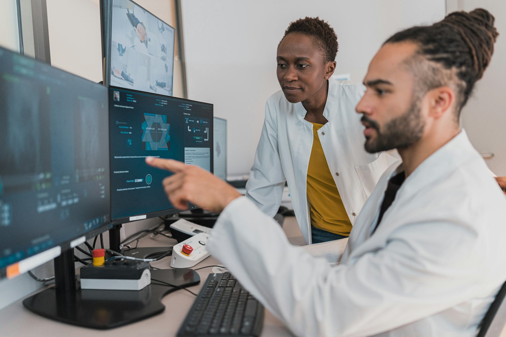Two doctors reviewing diagnostic scans on screens